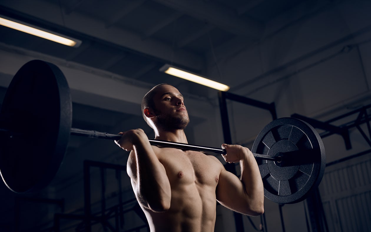 Muscle strength. Snatch exercise. Caracter athlete Training. Gym Dark.