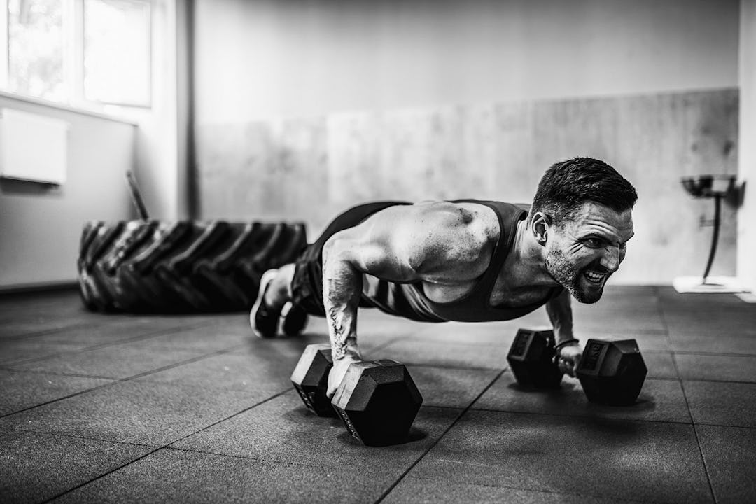 Man demonstrates dumbbell pushup.