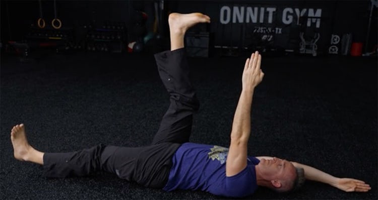 Shane Heins demonstrates the dead bug with arm and leg extended.